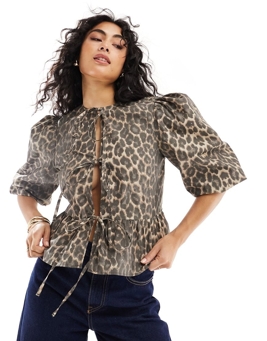 Person wearing ASOS DESIGN cotton poplin peplum tie shirt top in leopard print