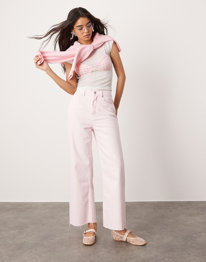 Woman wearing pastel pink jeans and white top