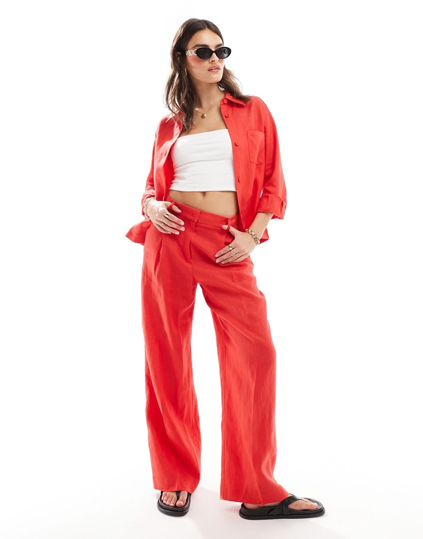 Woman wearing red co ord set with white tank top