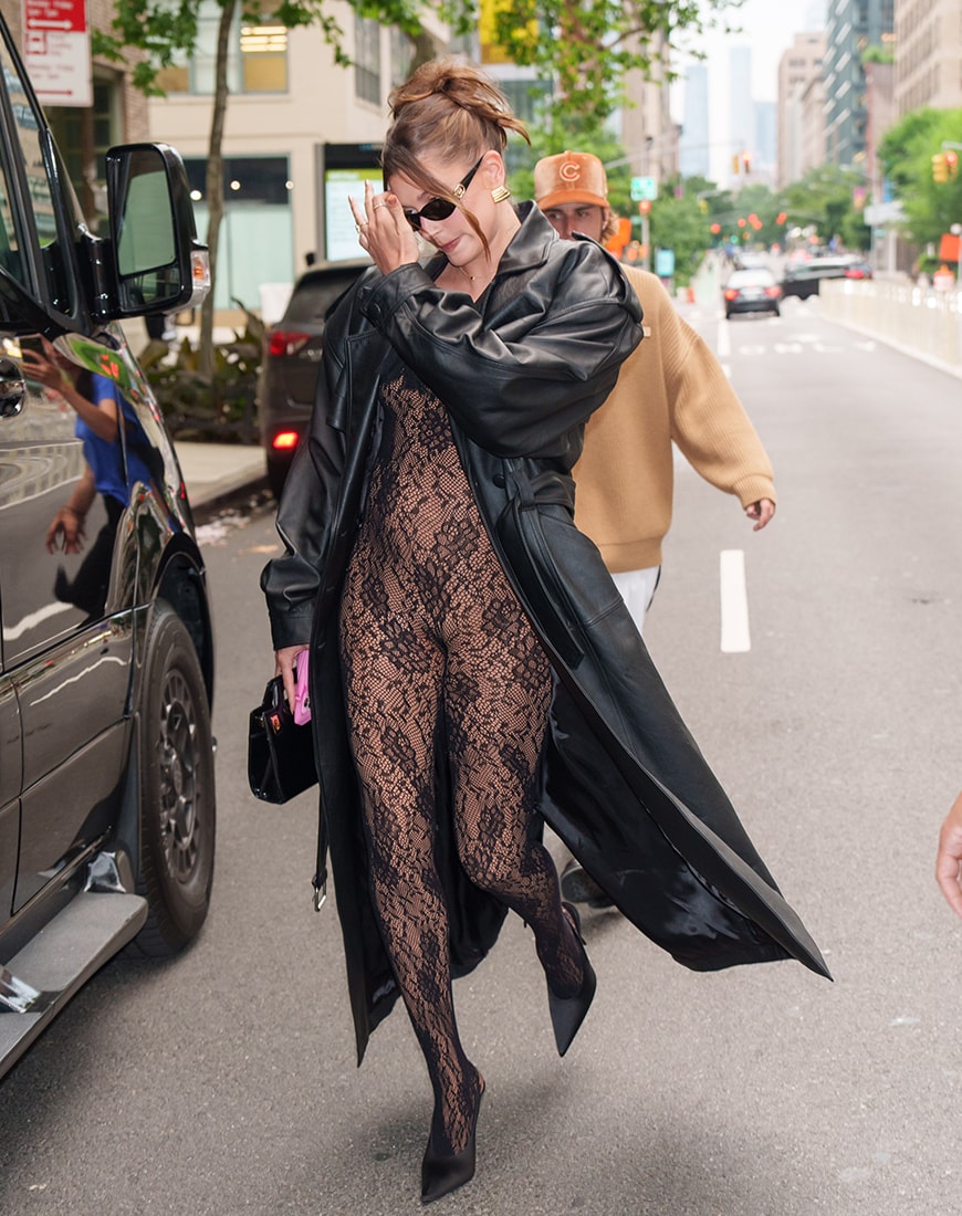 Hailey Bieber wearing black lace bodysuit and leather trench coat