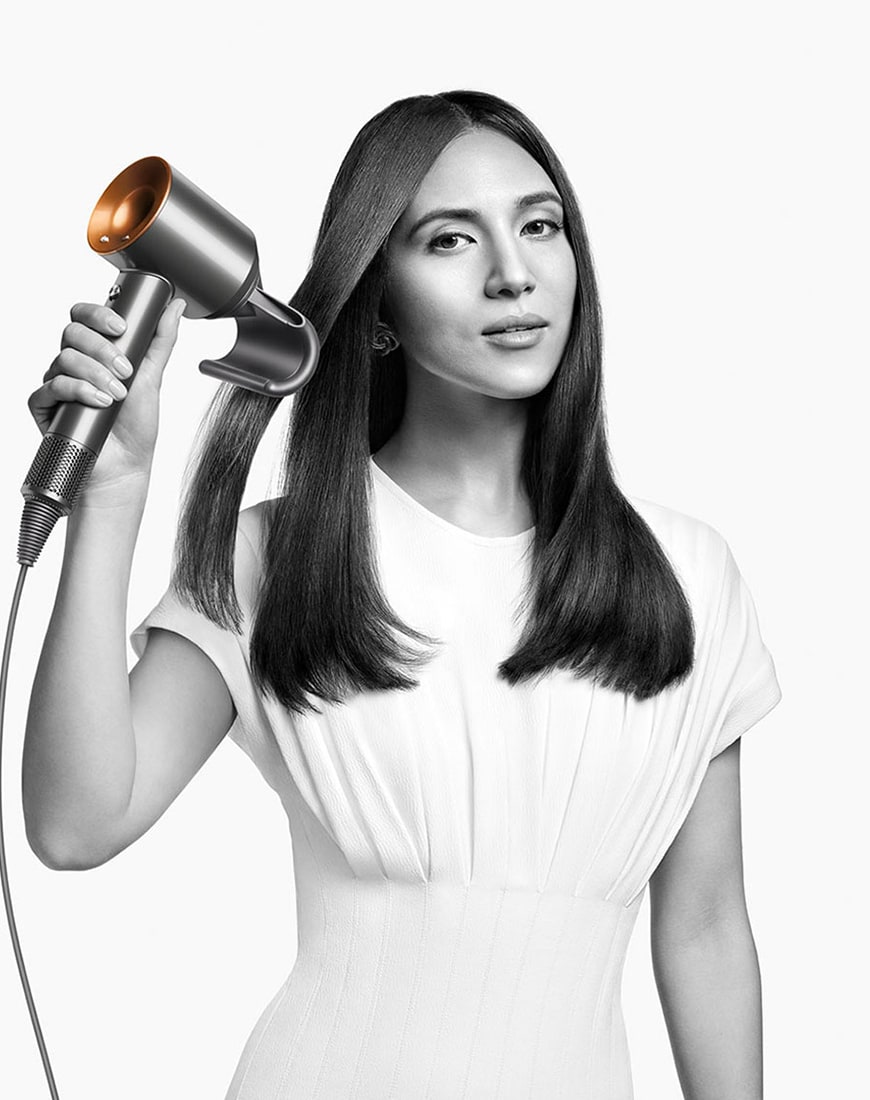 Woman using the Dyson Supersonic hairdryer