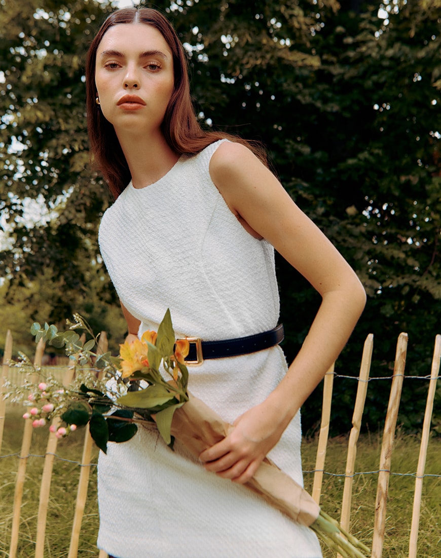 A woman wearing a white dress holding a bunch of flowers | ASOS Style Feed