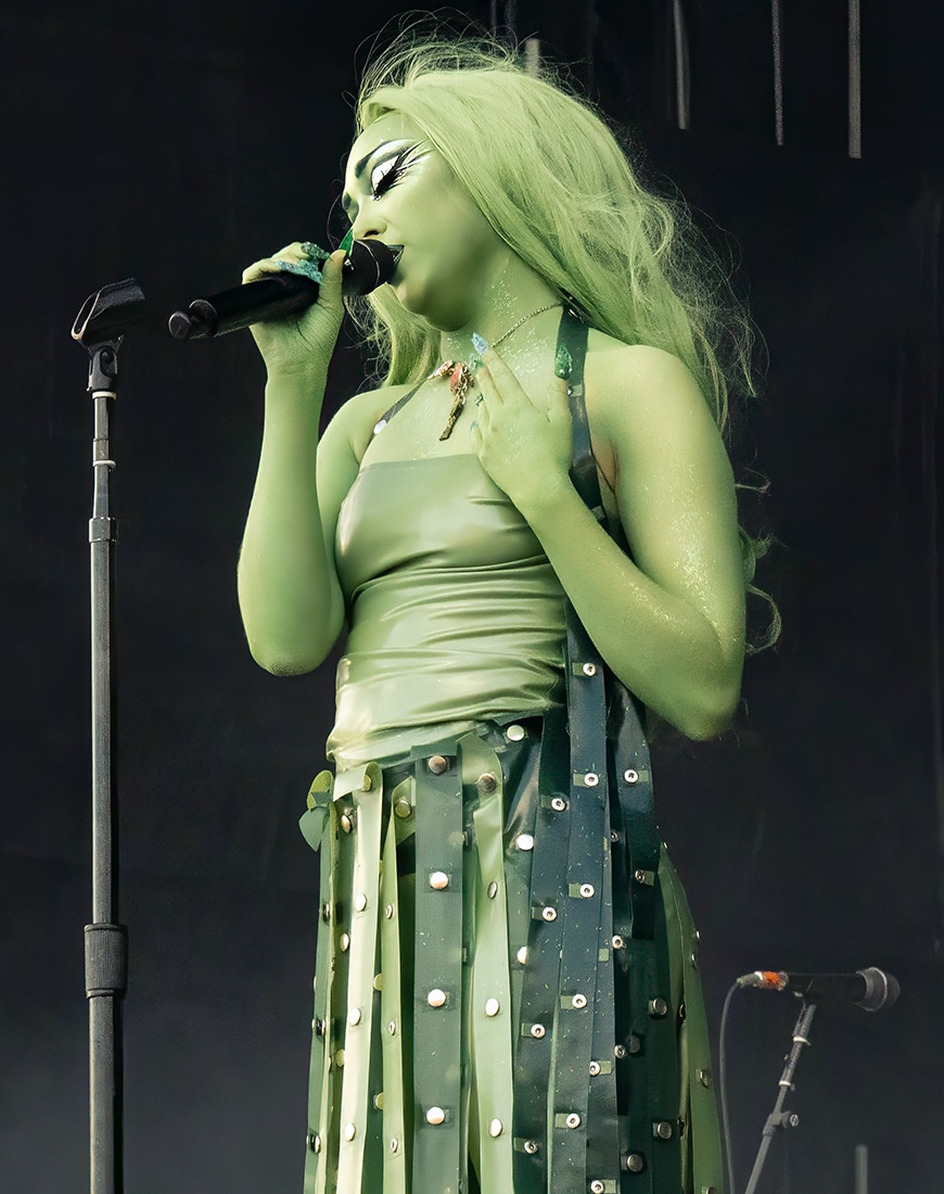 Chappell Roan painted in green cosplaying the Statue of Liberty while on stage singing