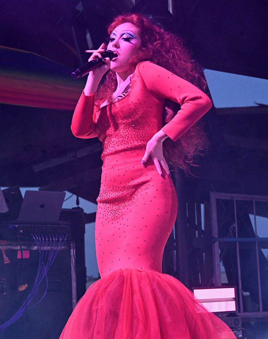 Chappell Roan wearing red dress while performing on stage