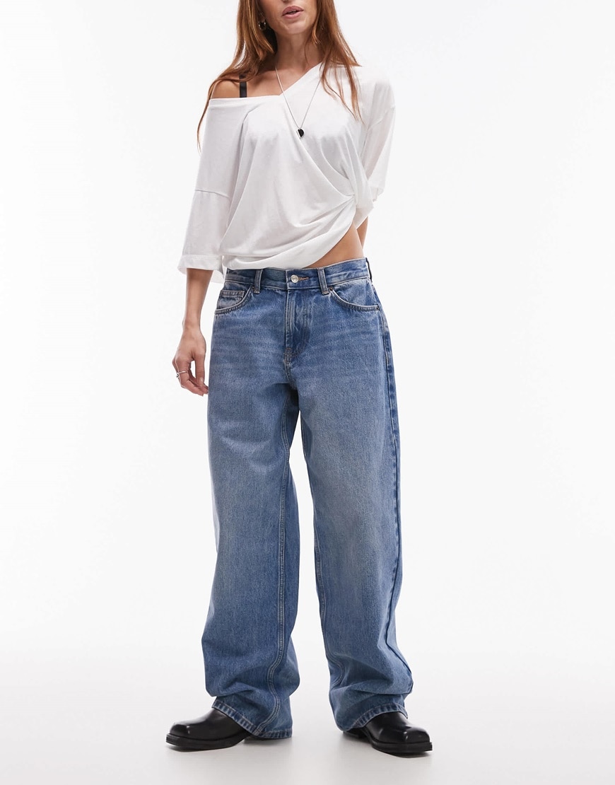 Model wearing light blue dad jeans with white long-sleeve t-shirt