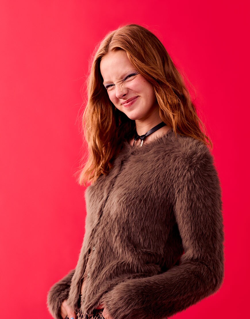 Woman on red background wearing brown knit cardigan and leopard print trousers | ASOS Style Feed