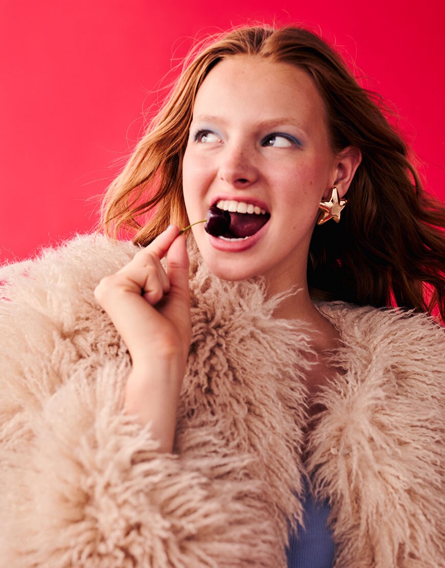 Woman wearing shaggy coat and maxi skirt on red background | ASOS Style Feed