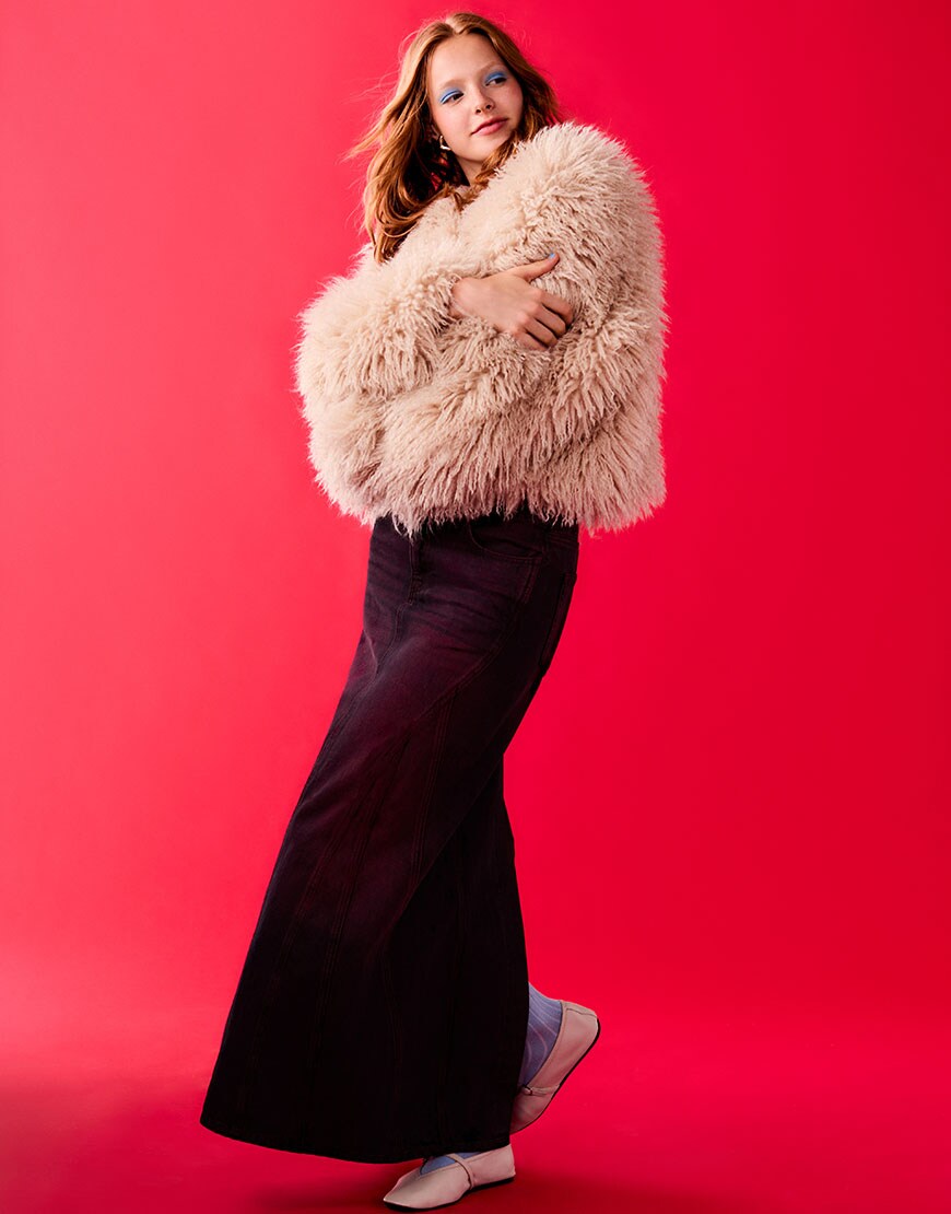 Woman wearing red shaggy fur coat on a red background | ASOS Style Feed