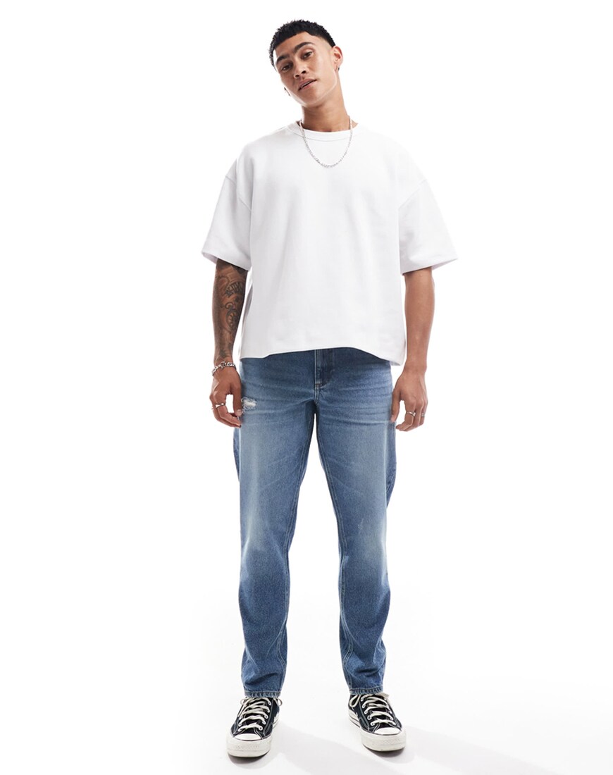 A man wearing blue tapered jeans with a white t-shirt | ASOS Style Feed