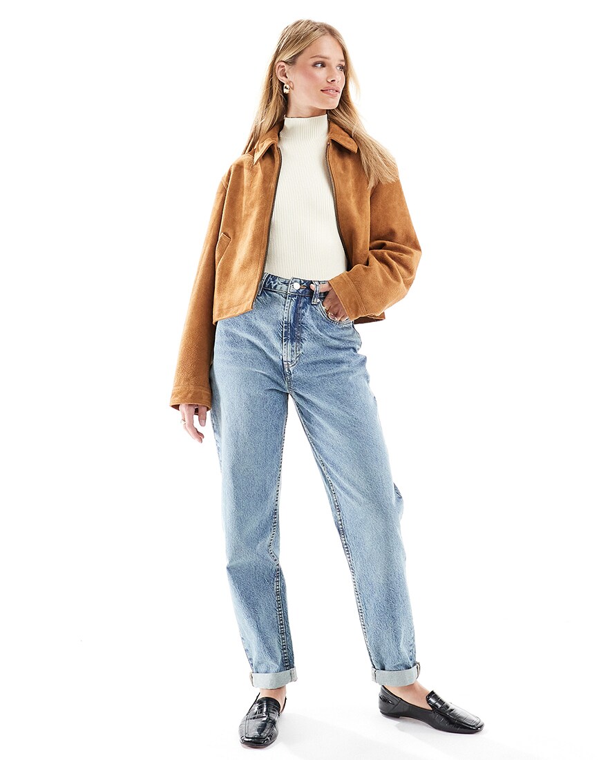 A woman wearing light wash mom jeans with a jacket | ASOS Style Feed