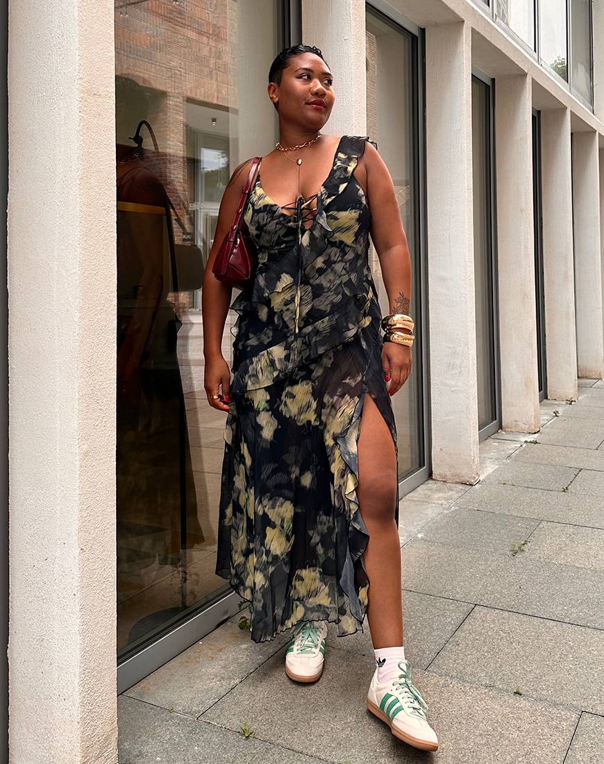 Ebony-Renee Baker wearing green floral dress with white and green Adidas Samba
