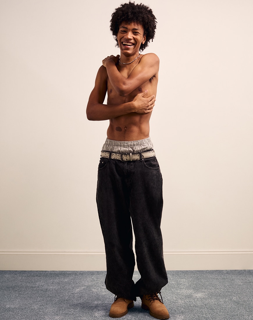 Man posing wearing no shirt and grey jeans