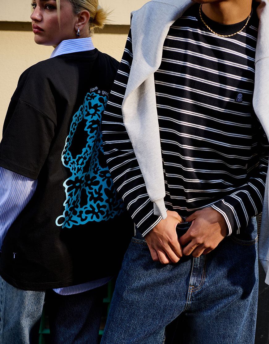 Female model wearing black graphic t-shirt and male model wearing striped t-shirt