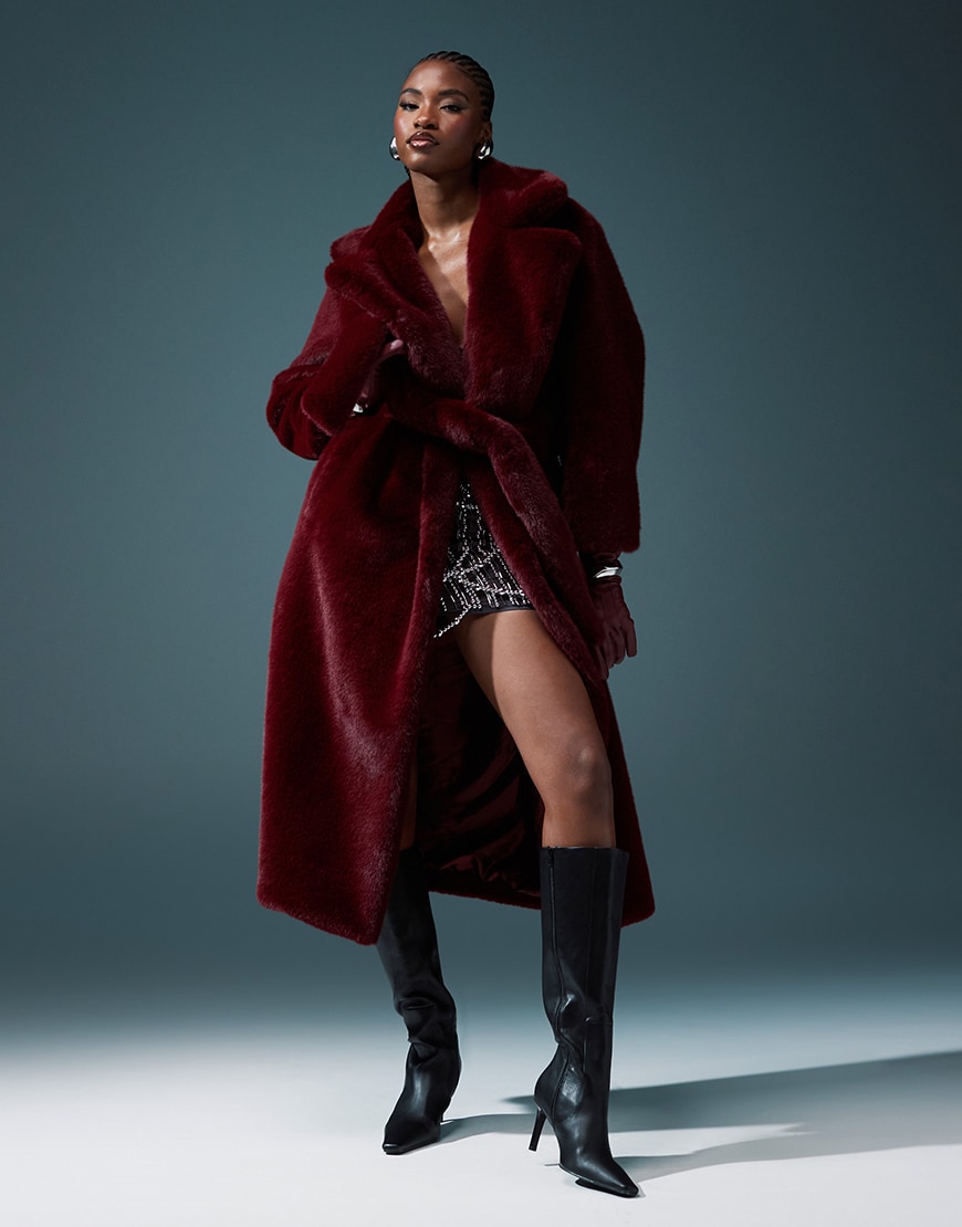 Model wearing long and large burgundy faux-fur coat