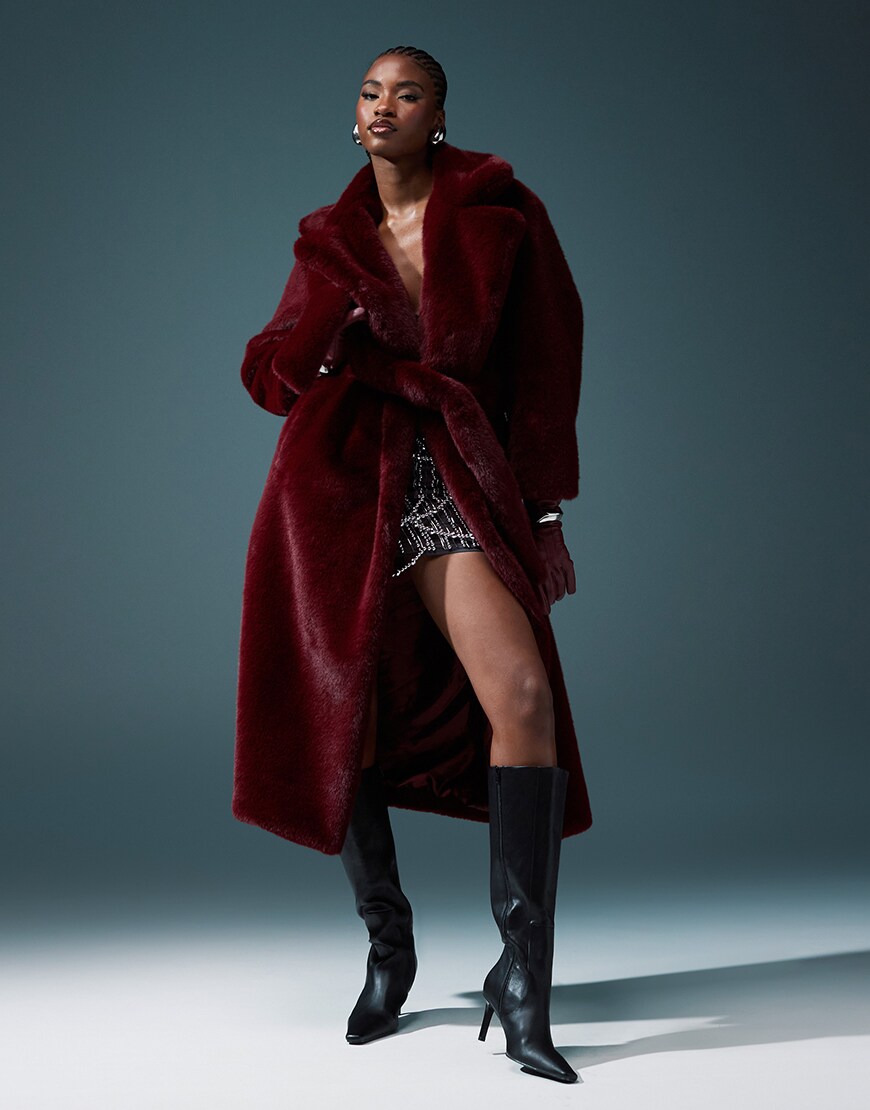 Model wearing long and large burgundy faux-fur coat