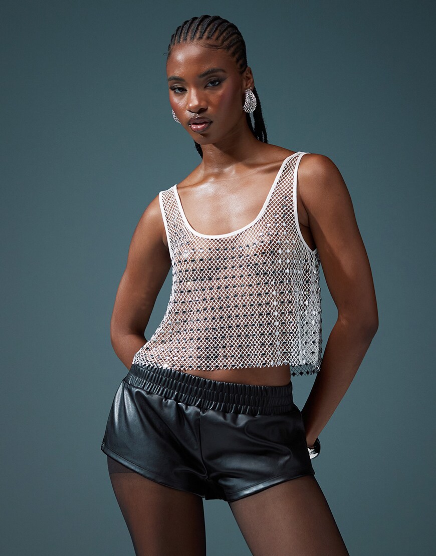 Model wearing chainmail silver sheer vest with leather black shorts
