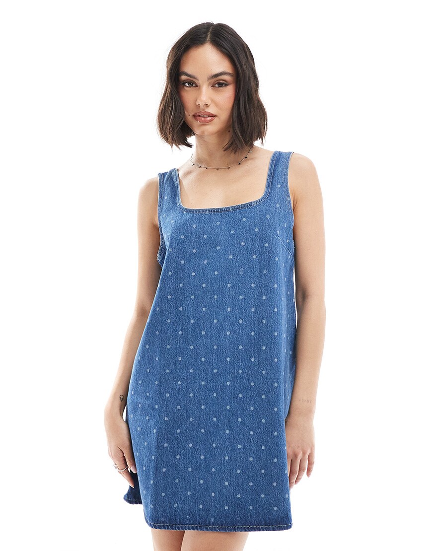 A model wearing a denim polka dot shift dress