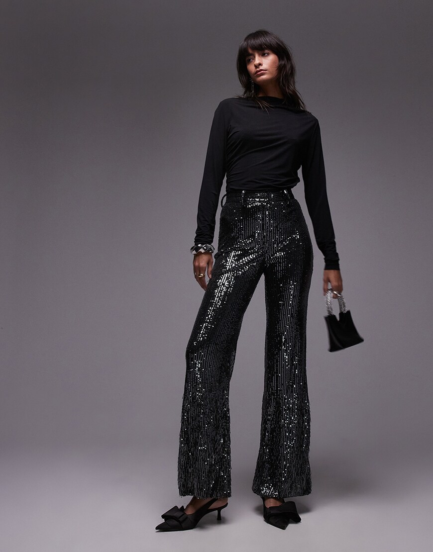 Model wearing sequinned black trousers