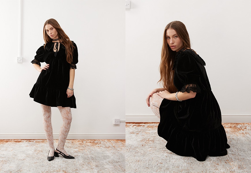 Model wearing black mini babydoll dress with white lace tights