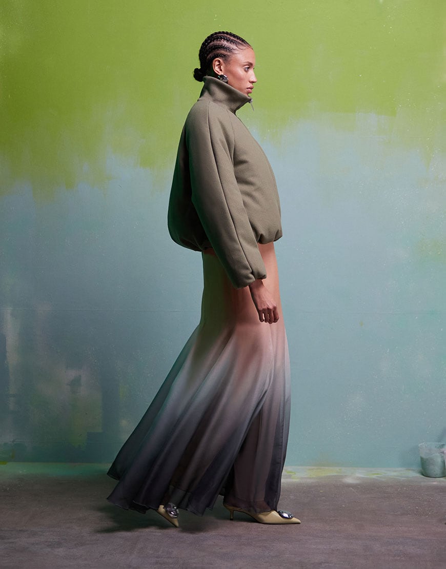 Model wearing cream knit jumper with green skirt and heels