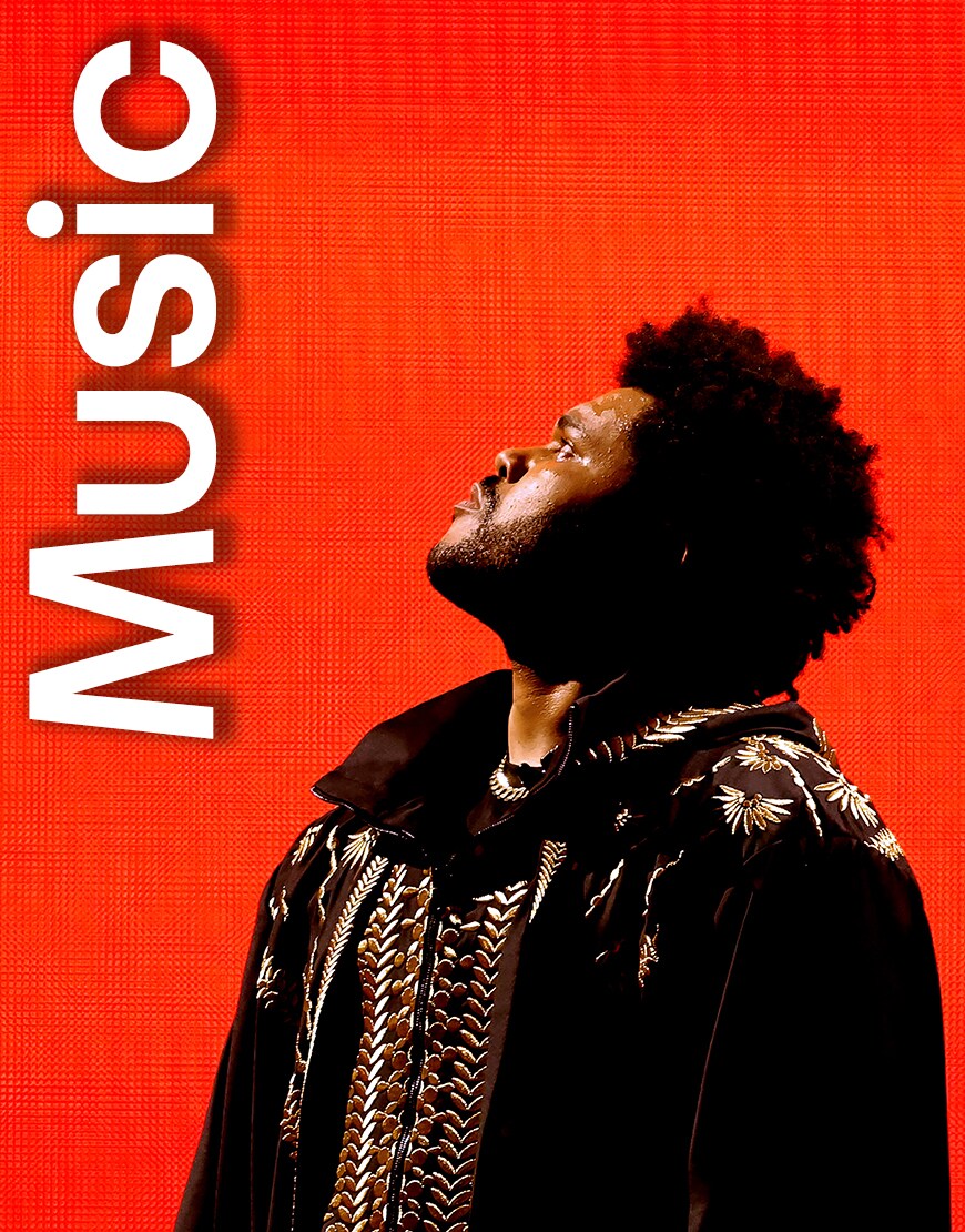 The Weeknd looking up on a red background