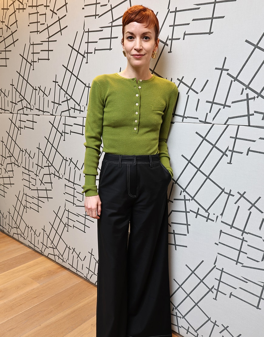 Britt Lower wearing a green top and jeans