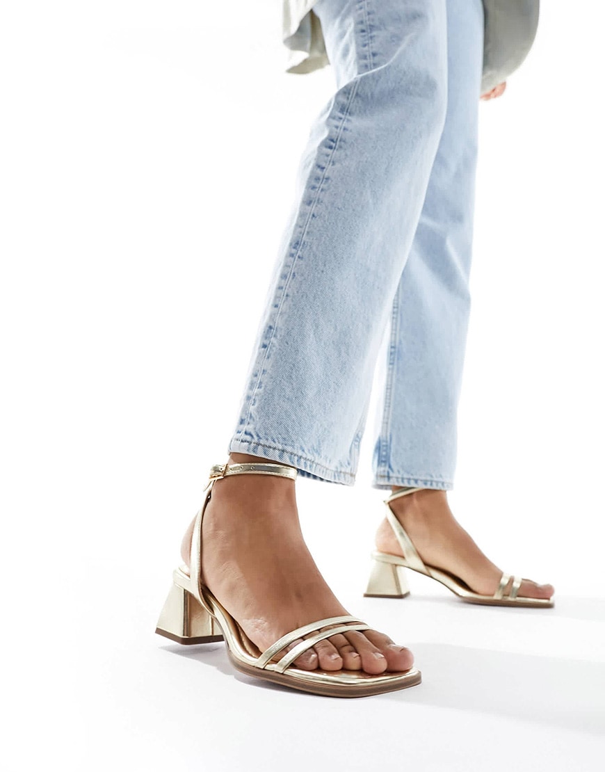 A model wearing gold heeled sandals