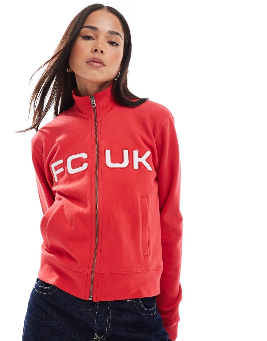 Woman wearing a red FCUK jumper