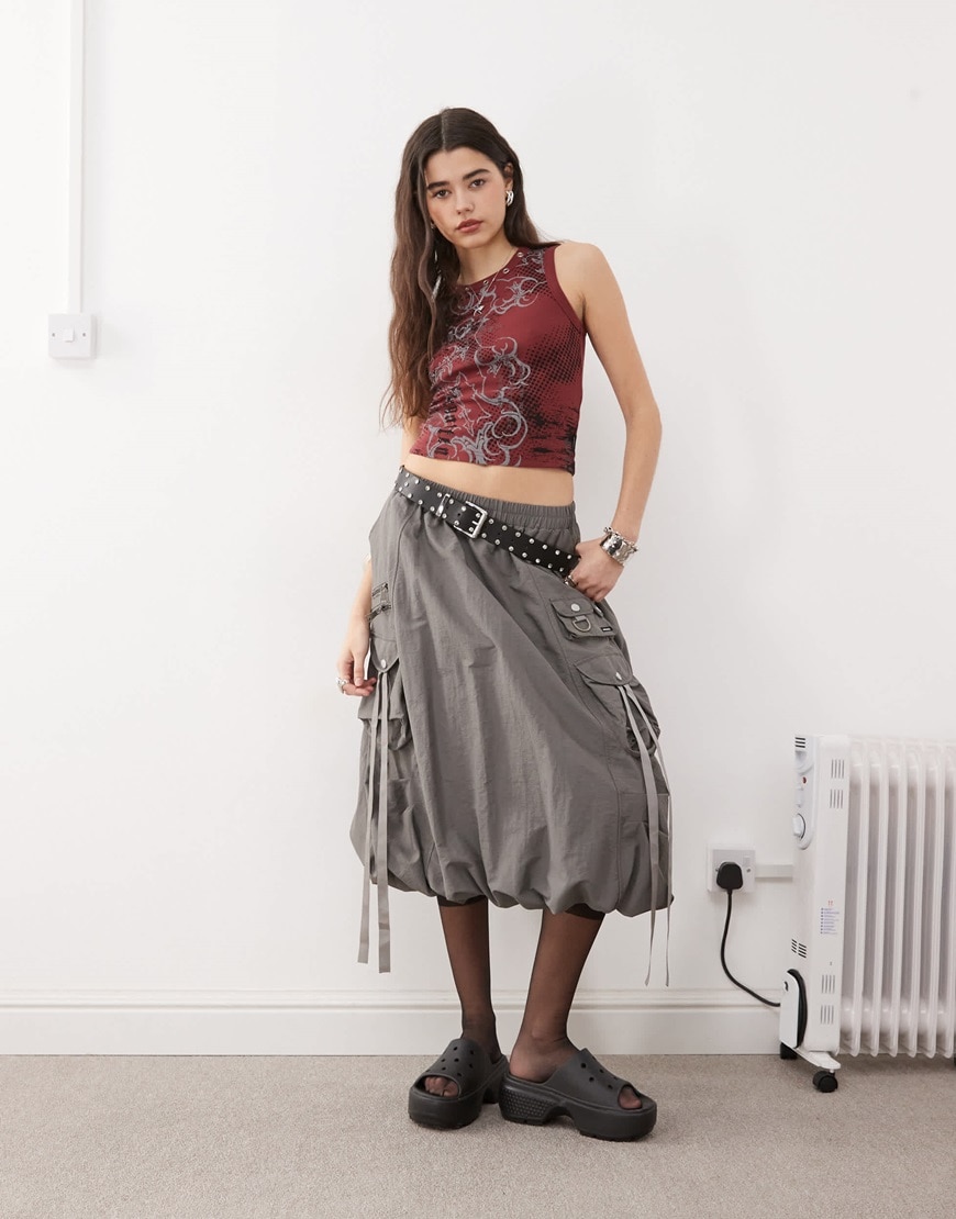 Model wearing a grey skirt and red top