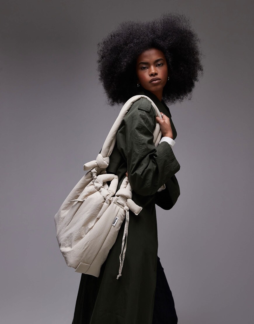 Model holding white crossbody bag