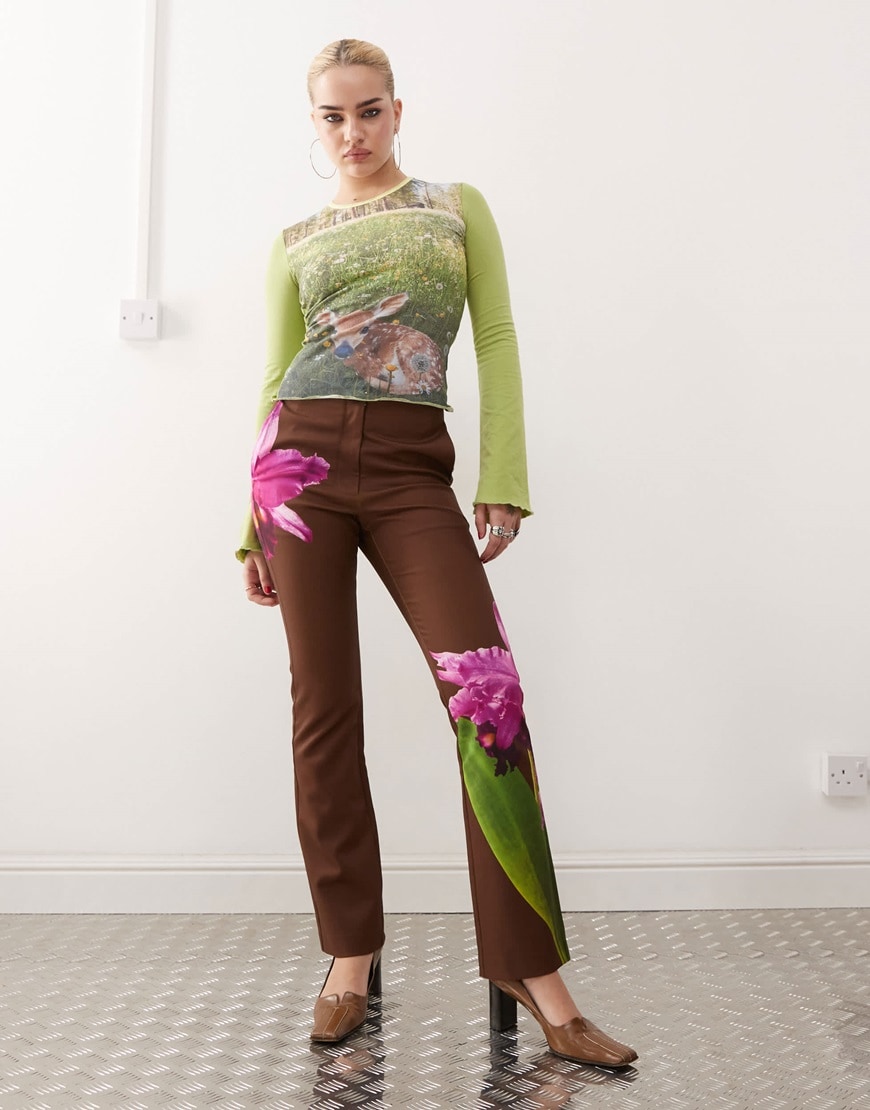 Model wearing a green top and brown trousers