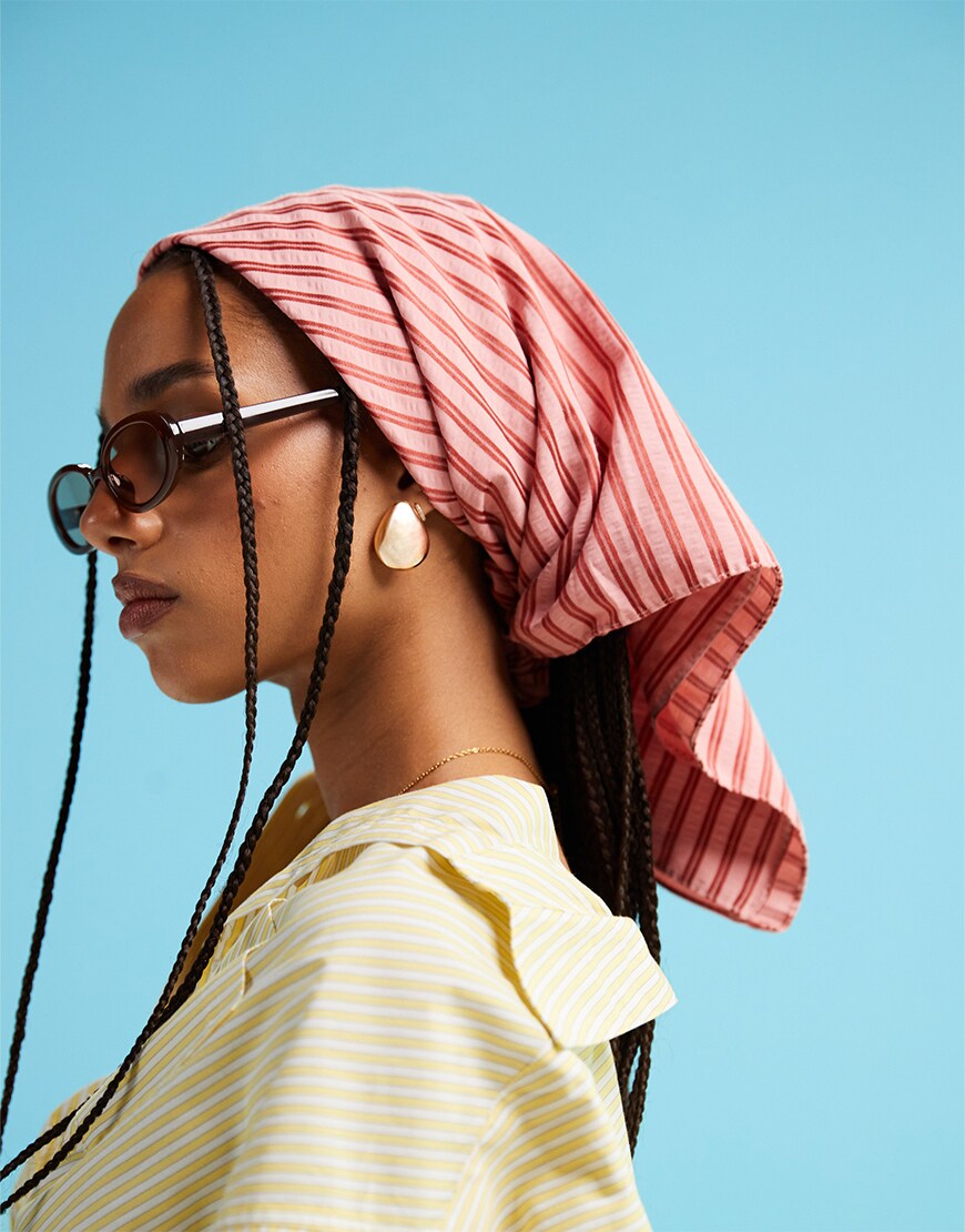 Woman wearing res striped headscarf and sunglasses