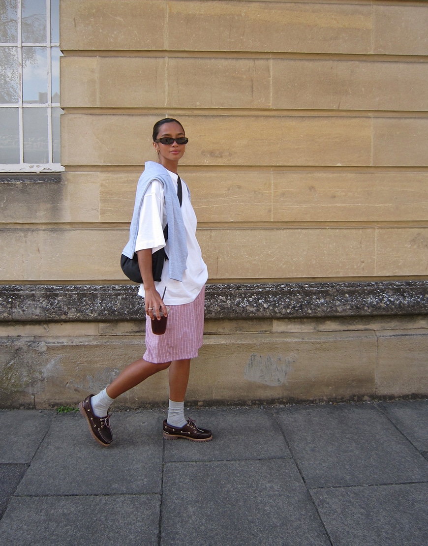 Hanna wearing a white t-shirt and striped shorts