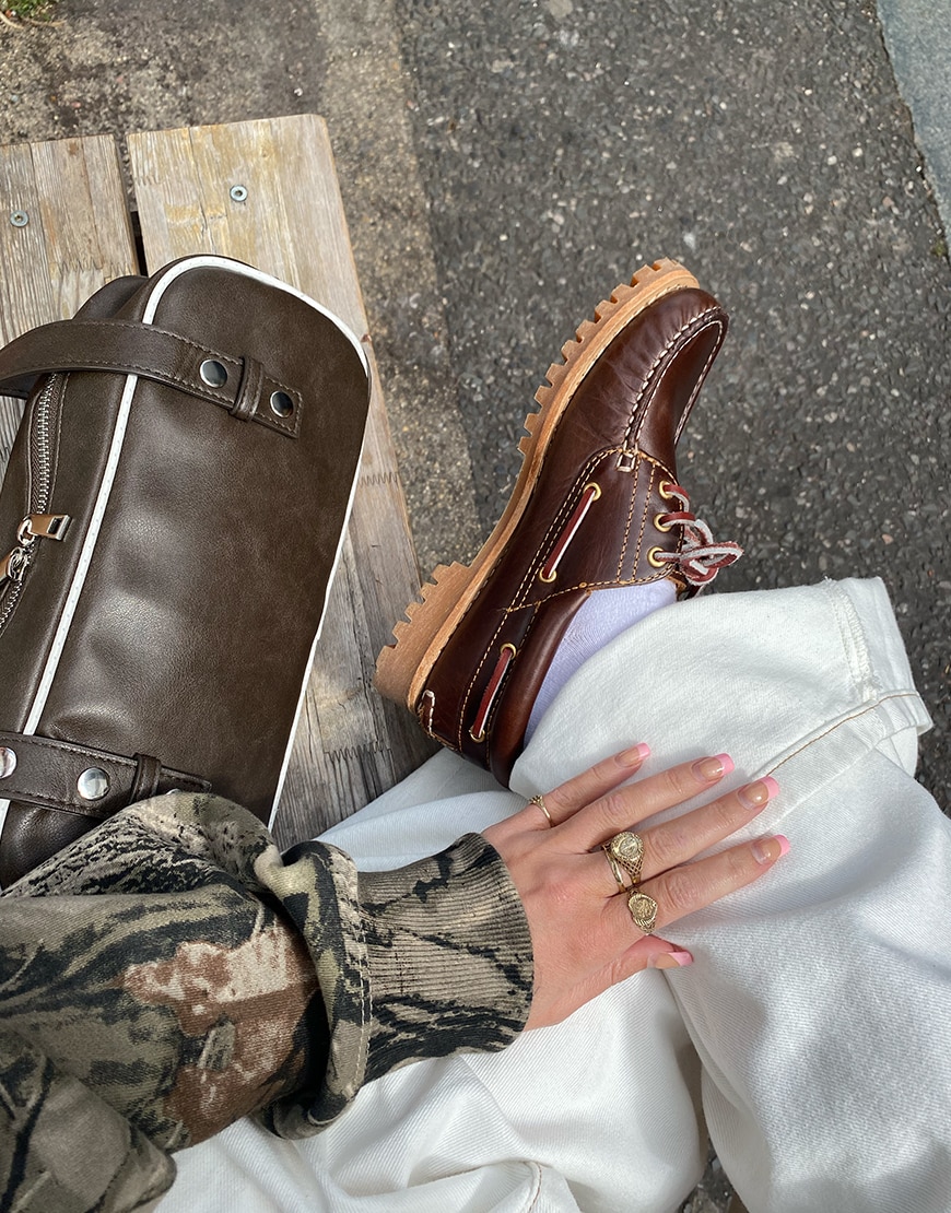 Woman wearing a green hoodie and Timberland boat shoes