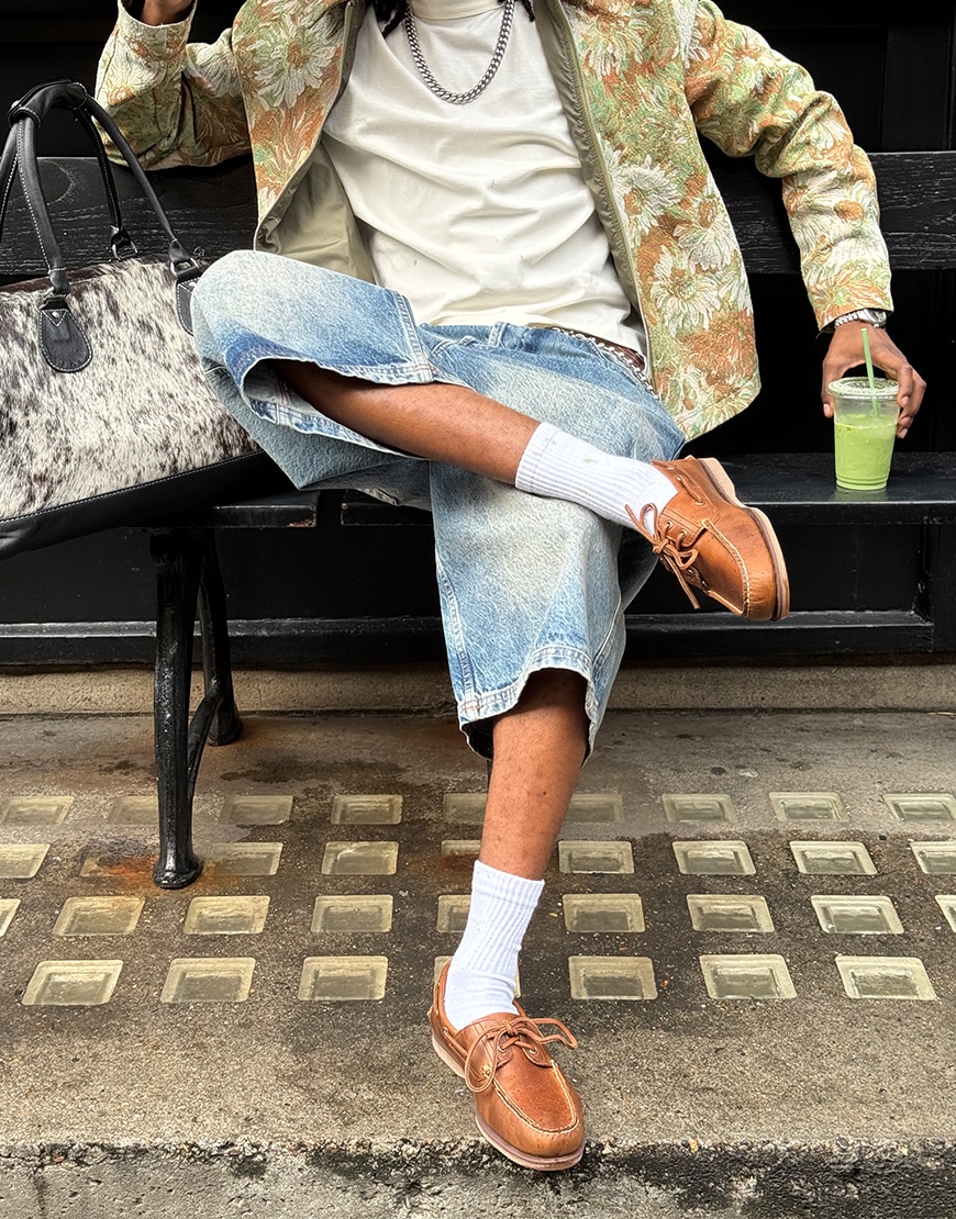 Man wearing a green hoodie and Timberland boat shoes