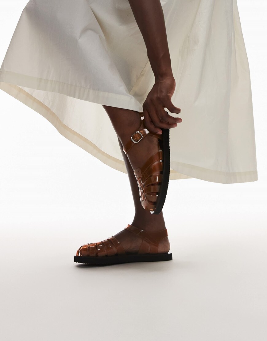 A model wearing beige strap up jelly sandals