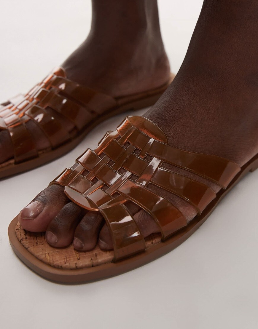 A model wearing tan jelly sandals