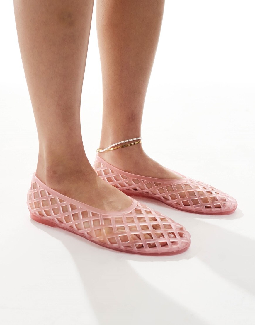 A model wearing pink cut out jelly shoes