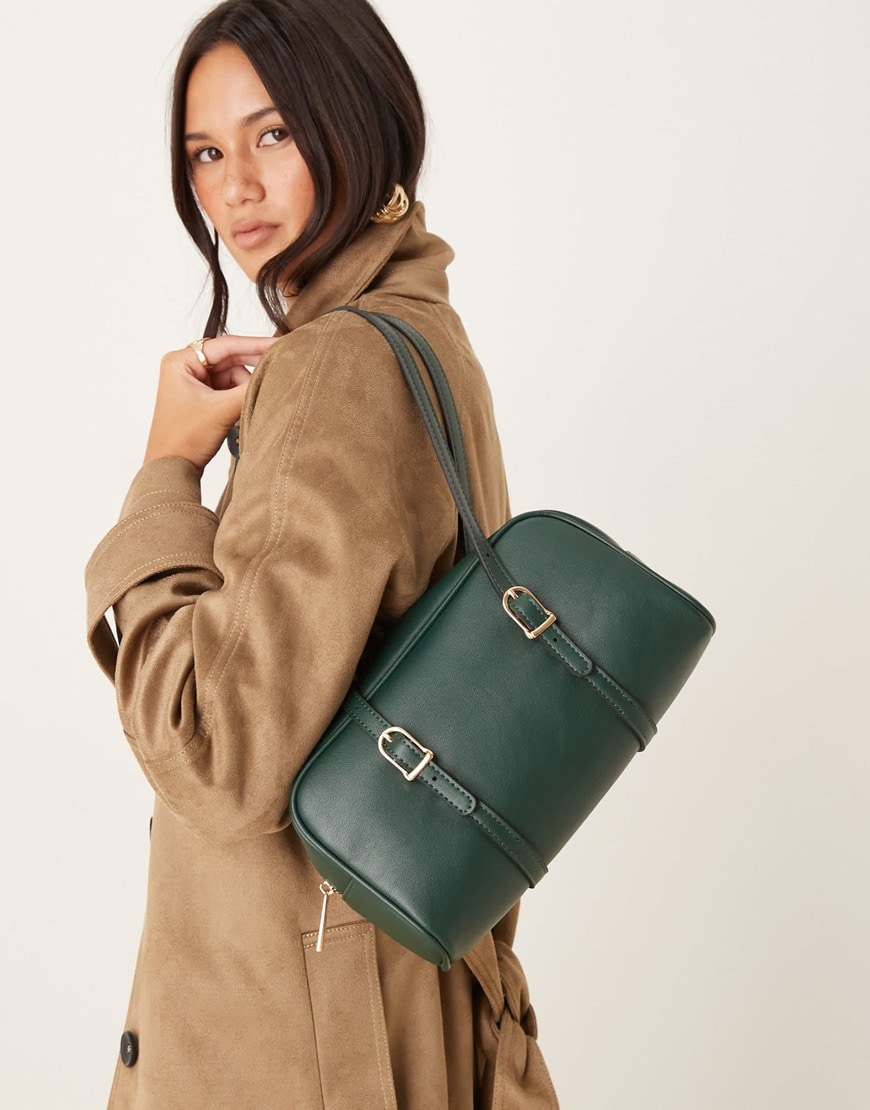 Woman holding a green east-west shoulder bag