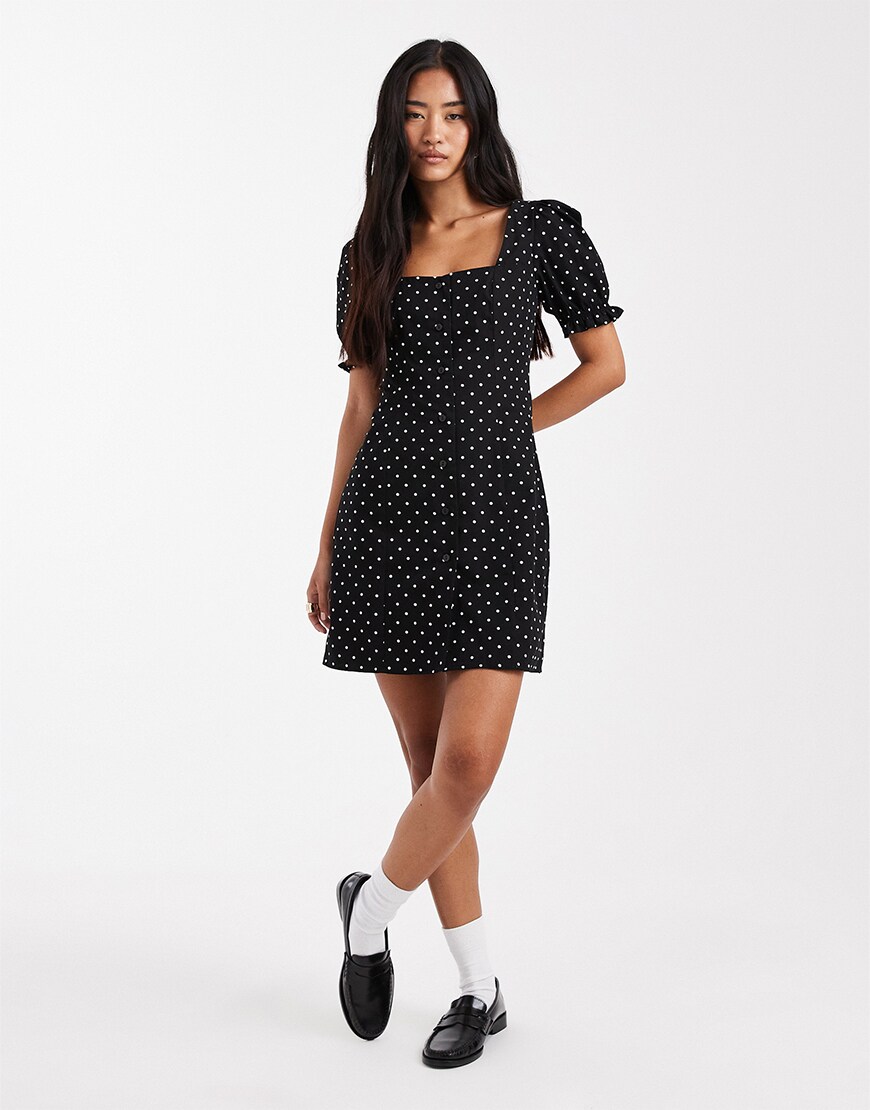 Woman wearing a black polka dot mini dress