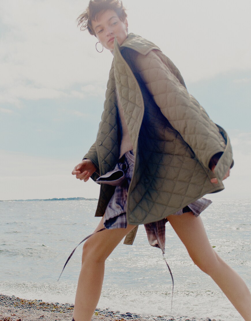 Woman wearing quilted green coat and plaid shirt | ASOS Style Feed