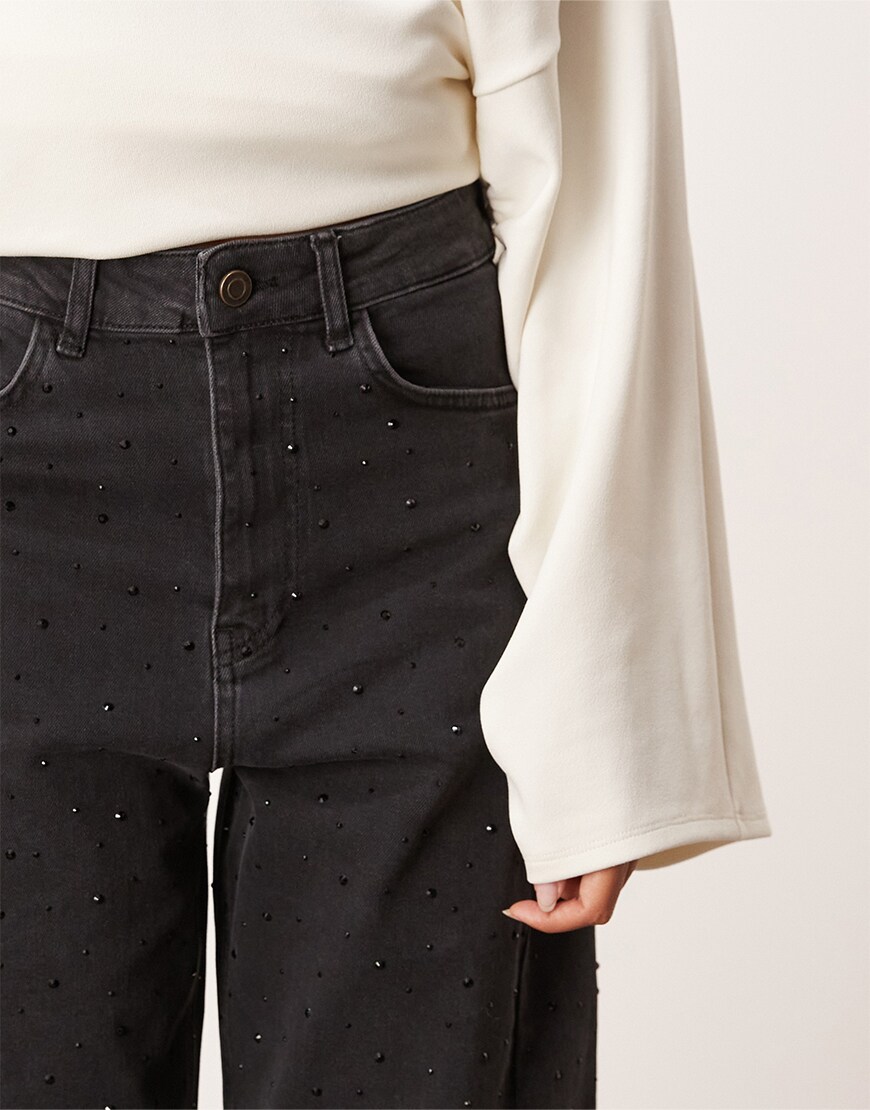 Close-up of white top and black hotfix jeans