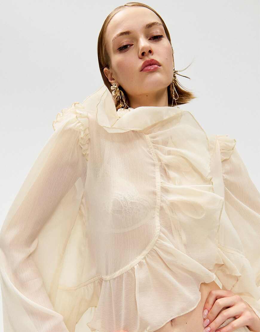 Woman wearing a neutral ruffled outfit
