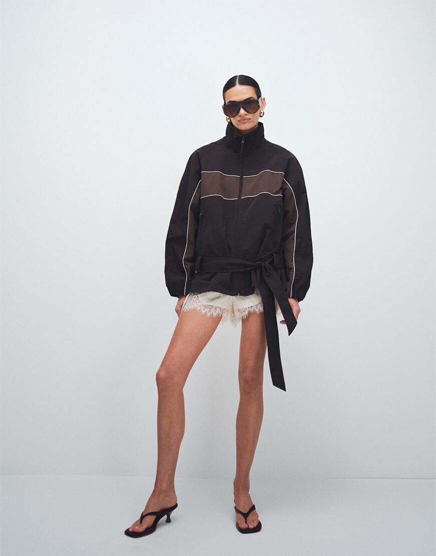 Woman wearing a track jacket and shorts
