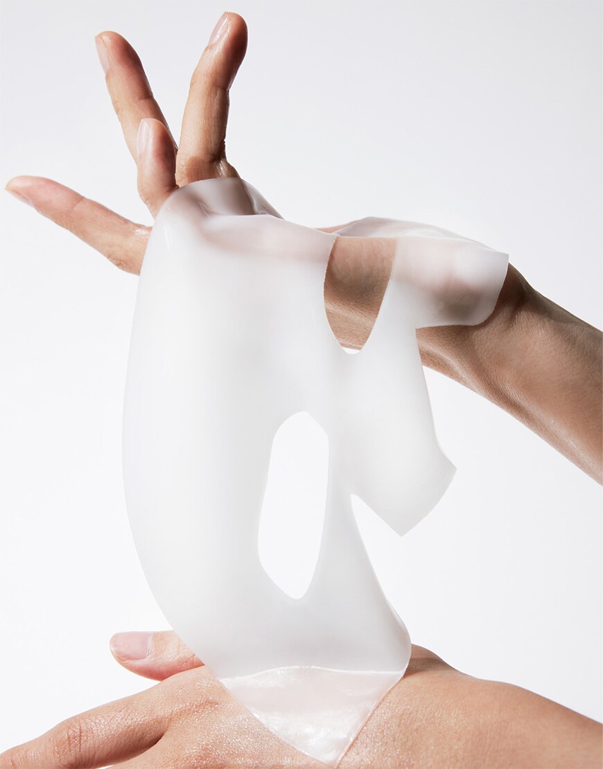 Hand playing in a sheet mask