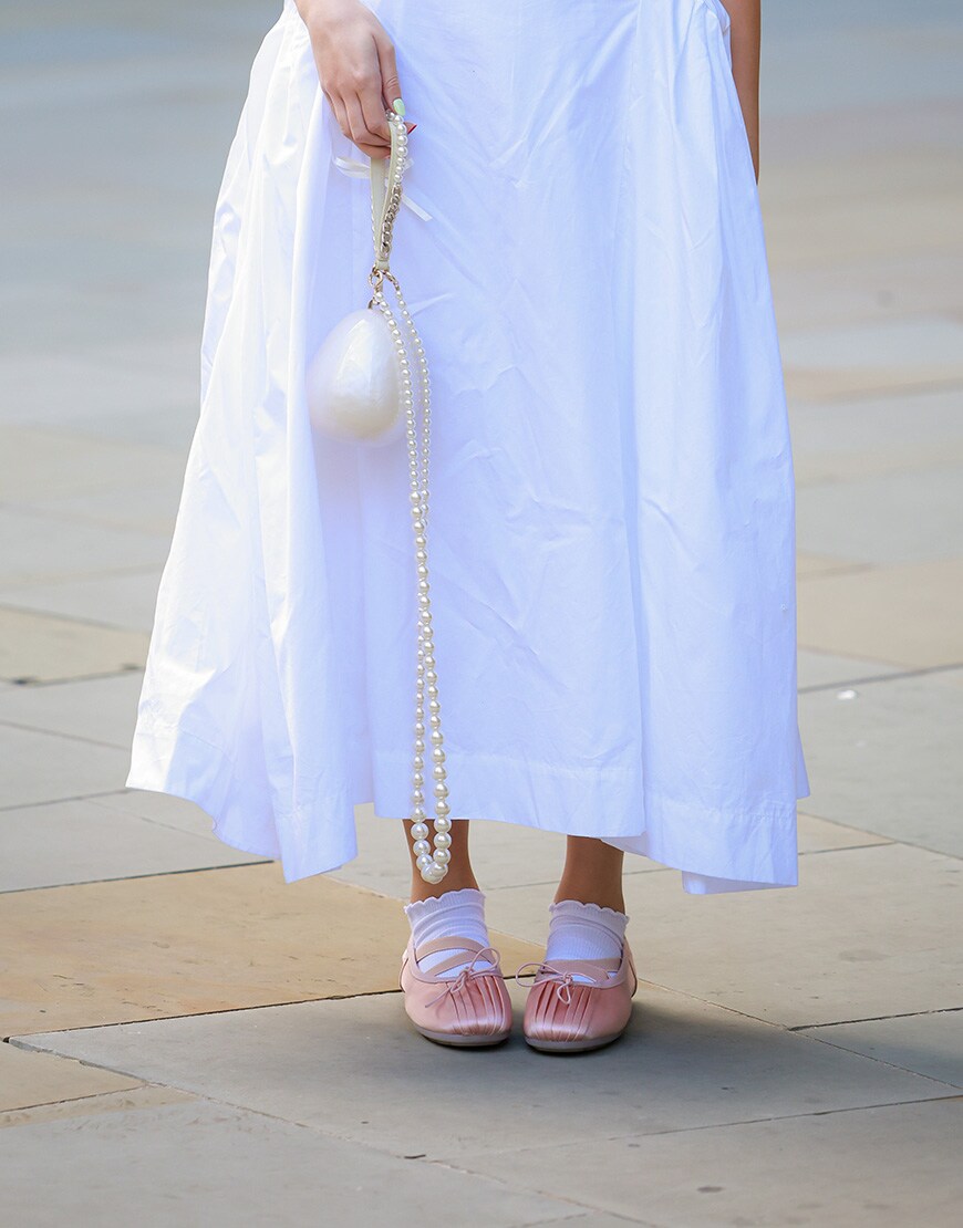 Woman wearing pink ballet flat sneakers and white poplin dress | ASOS Style Feed