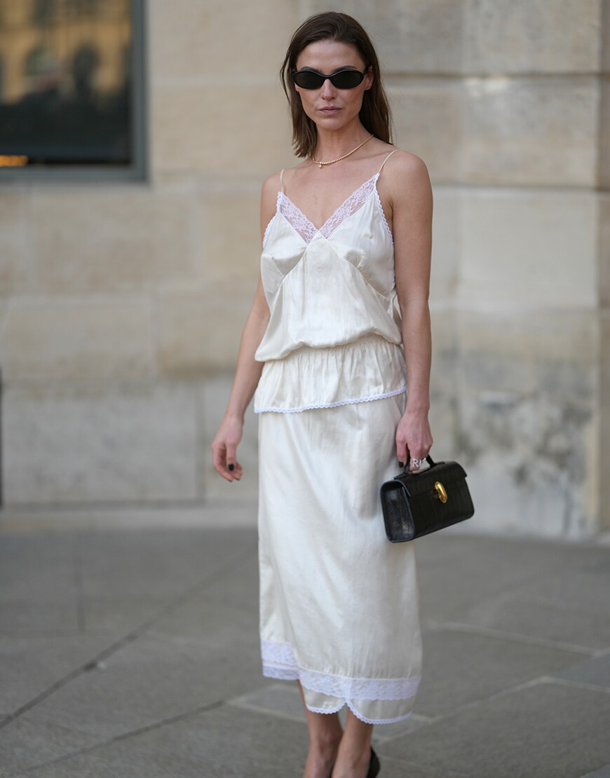 Woman wearing white skirt and top with black bag in Paris | ASOS Style Feed